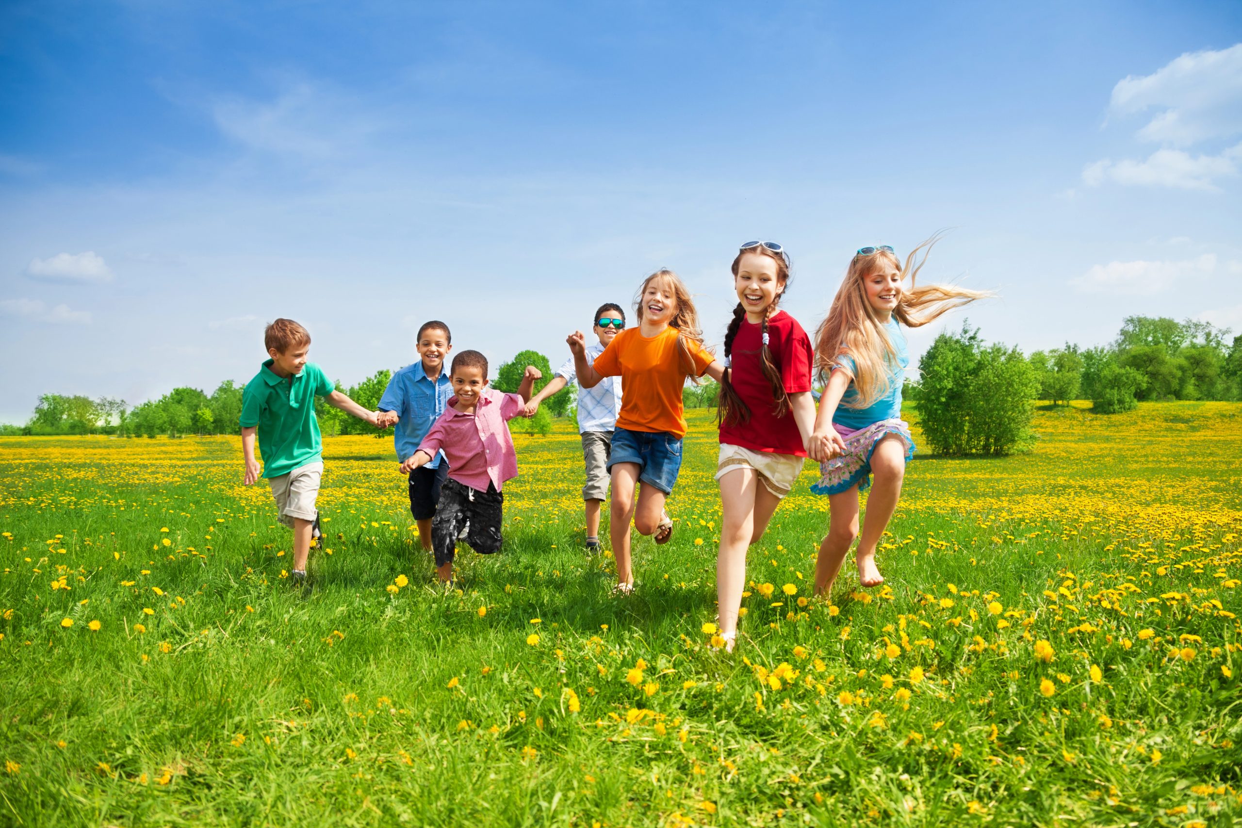 Children running through the grass on a sunny summer day, full of energy and joy.